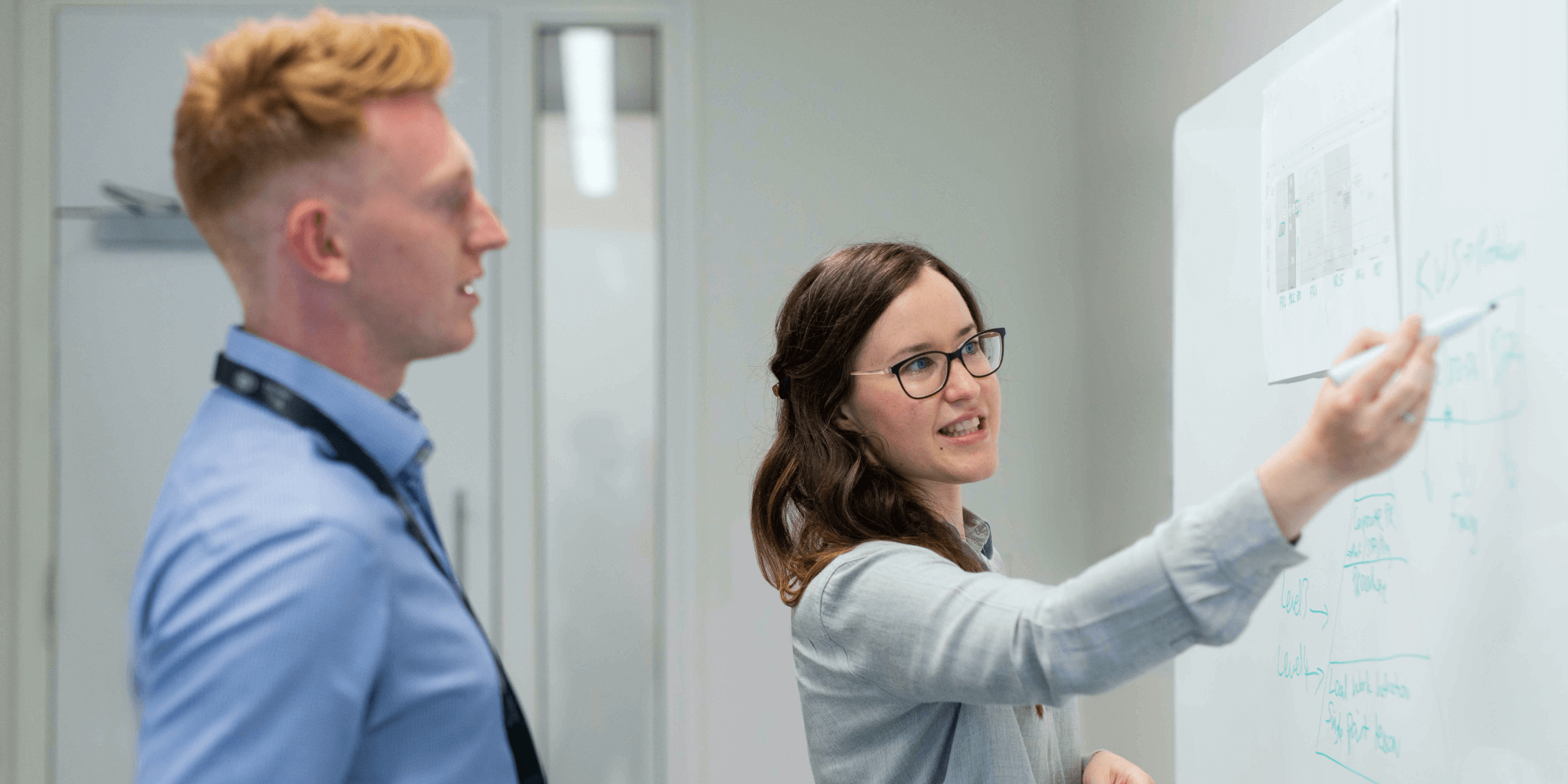 two CTE teachers discuss learning outcomes at a whiteboard