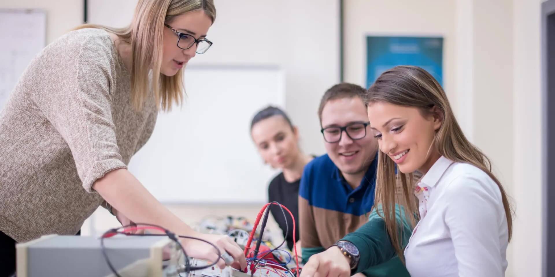 a CTE teacher helps students with a project