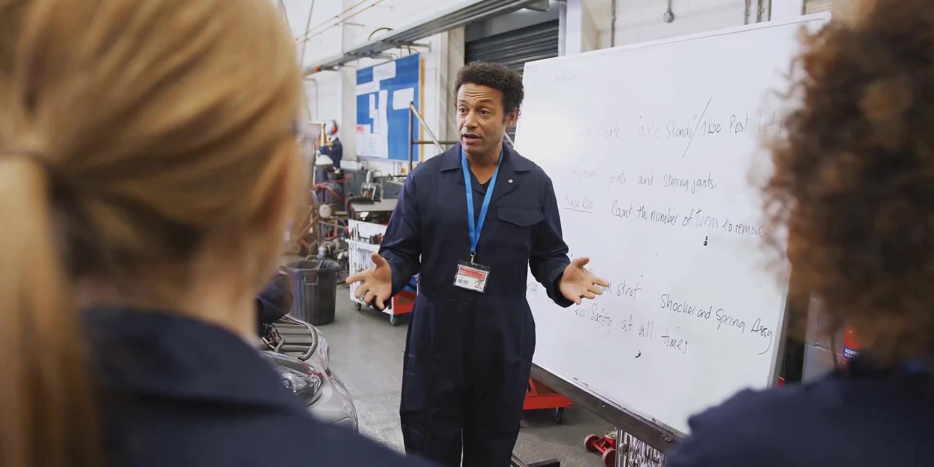 CTE instructor gives a lesson to an automotive shop class